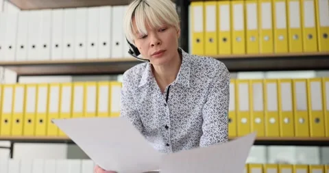 Call center worker customer service employee holding documents and communicating Stock Footage 240412943
