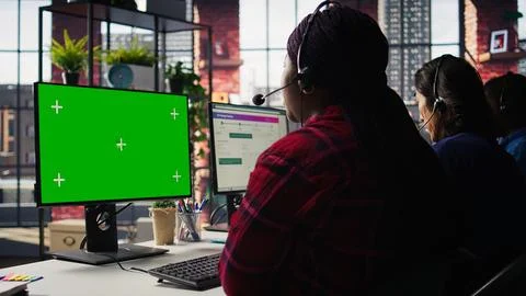Call center worker solving customers issues using green screen PC Stock Photos