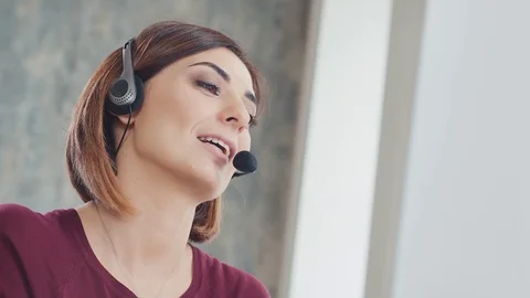 Call centre agent working in bright office talking with the headset Stock Footage 91007595