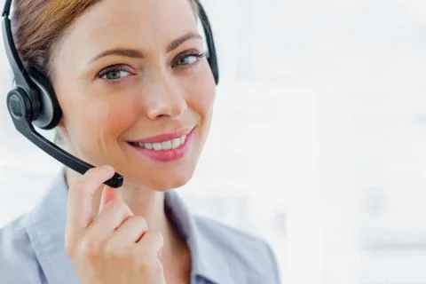 Call centre operator wearing headset smiling at camera Stock Photos