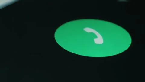 A call comes through on smartphone, man's finger swipes across an icon to answer Stock Footage 297785292