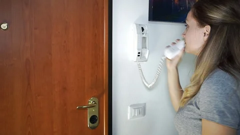 Call to the intercom, the girl answers Stock Footage 105197499
