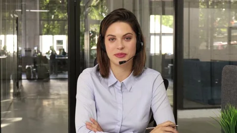 Call operator wears headset looking and speaking to webcam. Stock Footage 137885664