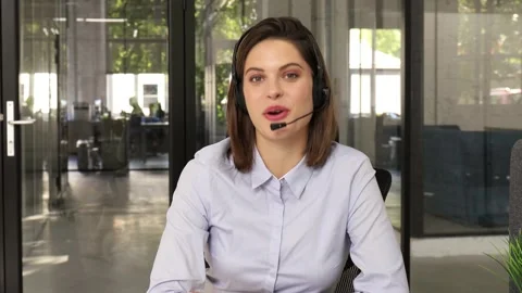 Call operator wears headset looking and speaking to webcam. Vidéo 137885675