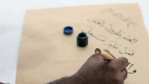 Calligrapher writes Arabic words on an old paper Stock Footage 105318411