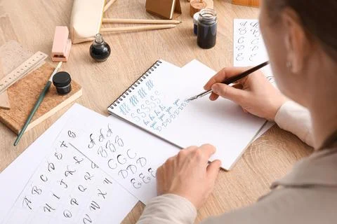 Calligraphy practice with dip pen and ink on paper, learning elegant handwrit Stock Photos
