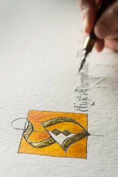 Calligraphy studio hand writes text with pen and nib letter S coated with gold Foto stock