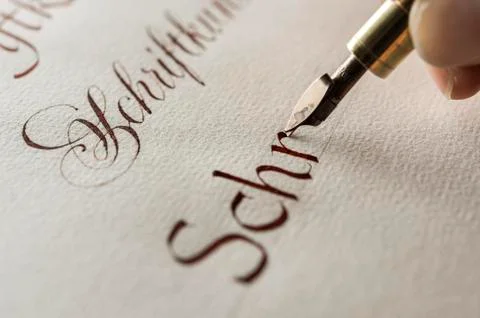 Calligraphy studio hand writes text with ink pen and nib Antiqua writing on Stock Photos