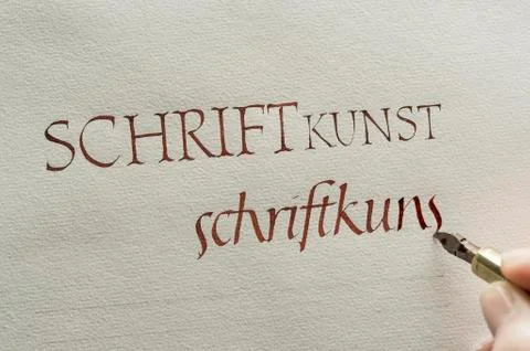 Calligraphy studio hand writes text with ink pen and nib Roman Italics on Stock Photos
