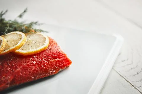 Calling all carnivores. a raw piece of meat garnished with slices of lemon. Stock Photos