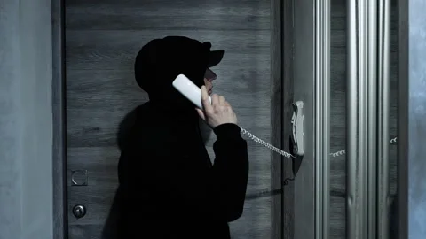 Calling a home intercom in an apartment, talking on a wired wall telephone Stock Footage 263662256