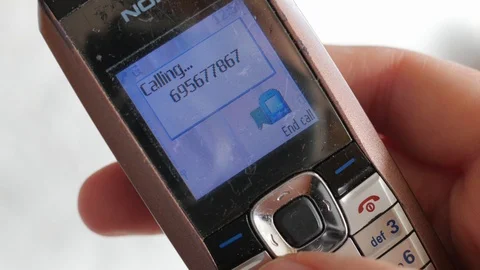 Calling on outmoded, old school model of  mobile phone Stock Footage 87184586