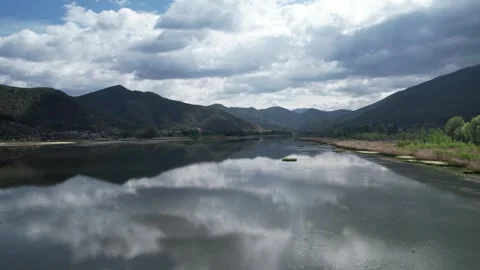 Calm aerial view of reflective mountain lake and clouds in Xinjiang China Stock Footage 337694500