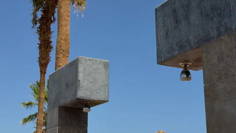 Calm Atmosphere Highlighting Sleek Concrete Bell And Palm Tower Under Clear Blue Vidéo 337940377