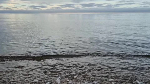Calm Baltic Sea Waves on Pebble Beach Under Cloudy Sky in 4K with Sound Stock Footage 323010161