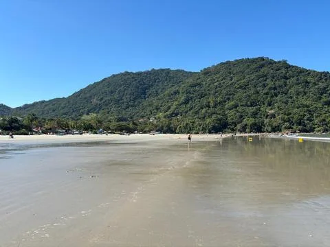 Calm beach with mountains in the background. Stock Photos