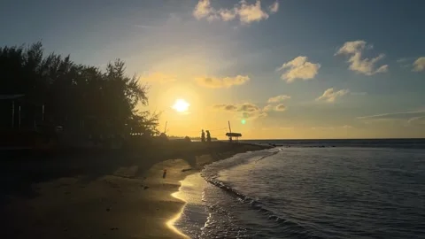 A calm beach at sunset with soft waves and golden light. Stock Footage 289566772