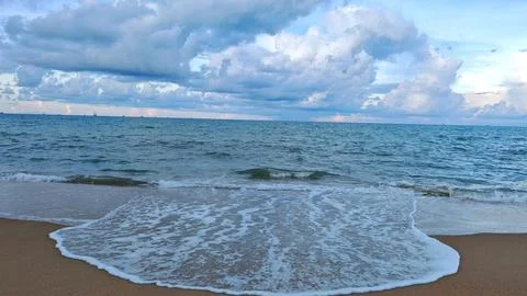 Calm Beach Waves under Cloudy Sky Фото