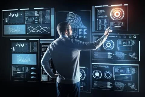 Calm bearded programmer pointing to the screen while working Stock-Fotos