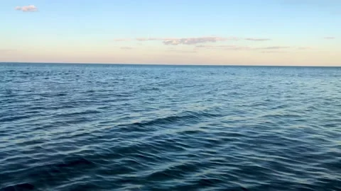 Calm black sea, with a slightly cloudy blue sky, shot from the beach Stock Footage 201973000