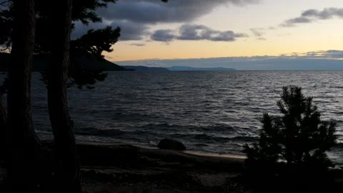 The calm blue evening waves of Lake Baikal run onto the shore of the lake. Stock Footage 294626002