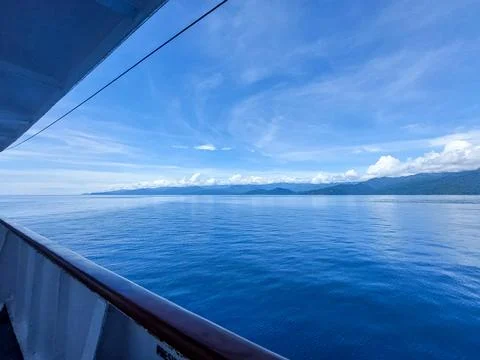 Calm Blue Ocean and Distant Mountain from Ferry Deck. Stock Photos