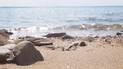 Calm blue ocean waves shimmering under bright daylight rocky beach. Stock Footage 337405987