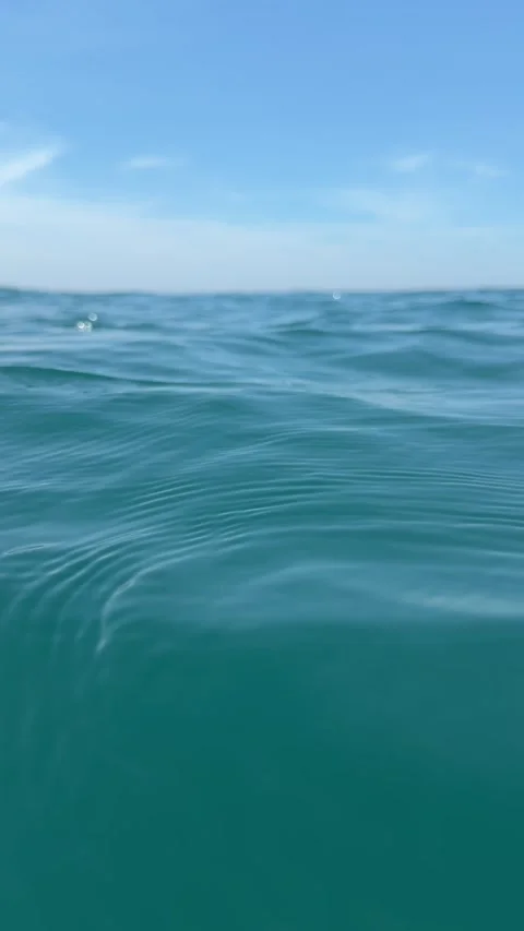 Calm blue sea surface with gentle waves under a clear sky and a wide open horizo Stock Footage 340890450