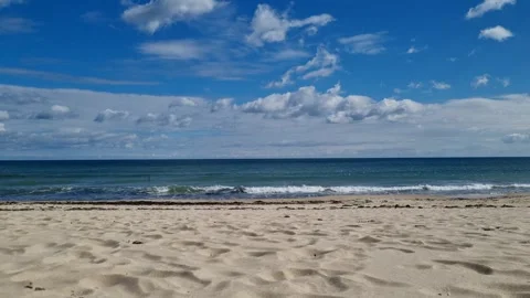 Calm blue sea waves rolling on sandy beach under clouds Stock Footage 319572963