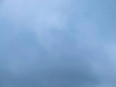Calm blue sky texture with soft clouds, atmospheric haze and copy space 库存照片