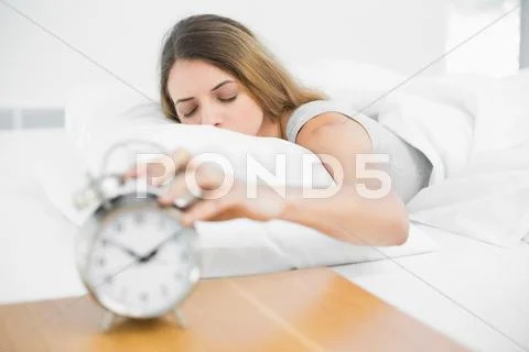 Calm brunette woman lying on her bed with eyes closed Stock Photos