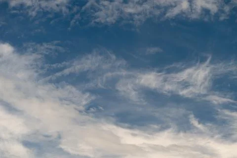 Calm clouds glide softly across tranquil sky filled with gentle hues. Peacefu Stock Photos