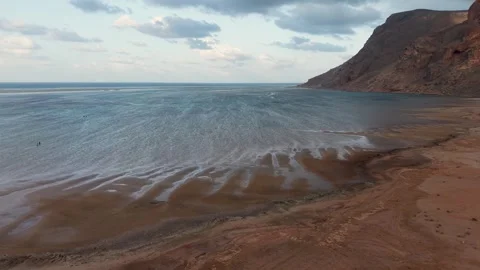 Calm coastal beach with cliffs and cloudy sky Stock Footage 335748671