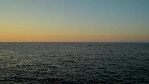 Calm dark sea surface stretching to horizon under clear gradient sky at dusk Stock Footage 341702540