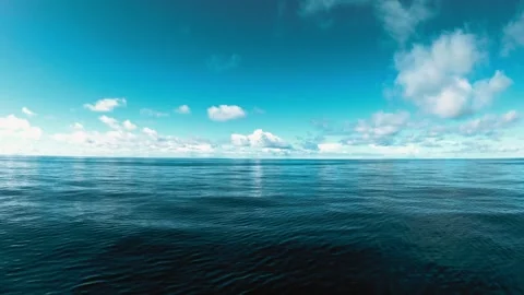 Calm deep blue ocean waves under a sunny sky with clouds Stock Footage 332729051
