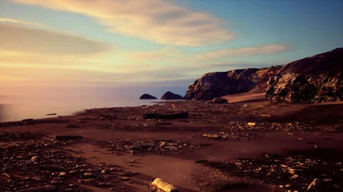 Calm dusk over beach with soft gradient sky and scattered stones Stock Footage 342428160