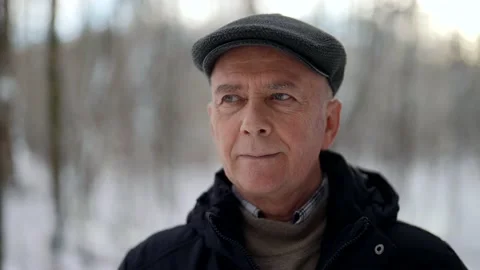 Calm elderly man is walking in forest in winter day, portrait shot in nature Vidéo 169415962