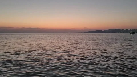 Calm Evening Sea with Soft Sunset Sky and Distant City Lights, 1080p Vídeos de archivo 329427213