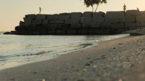 Calm evening sea surf, someone running in the background Stock Footage 343375773