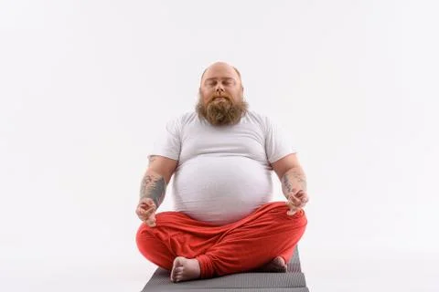 Calm fat guy doing yoga Stock Photos
