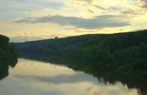 Calm flow of the river with reflection of clouds at sunset. Landscape. Stock Photos
