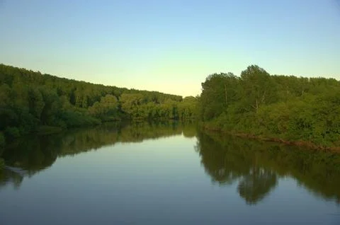 Calm forest lake at sunset with reflection of forest and sky. Landscape. Stock Photos