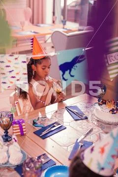 Calm girl drinking juice while being at the theme party Stock Photos