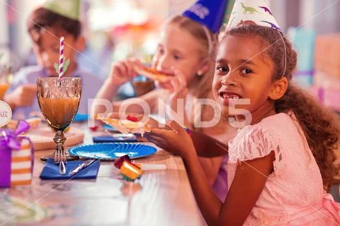 Calm girl smiling while eating pizza with friends Stock Photos