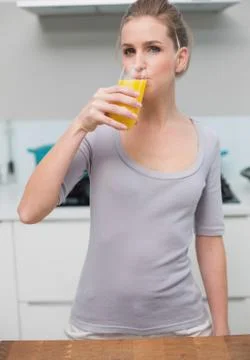 Calm gorgeous model looking at camera drinking orange juice Stock Photos