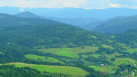 Calm green valley with fields and forest near old hills Stock Footage 327011384