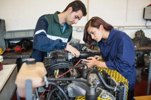 Calm instructor and trainee checking a machine Stock Photos