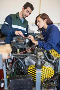 Calm instructor explaining a machine to trainee Stock Photos