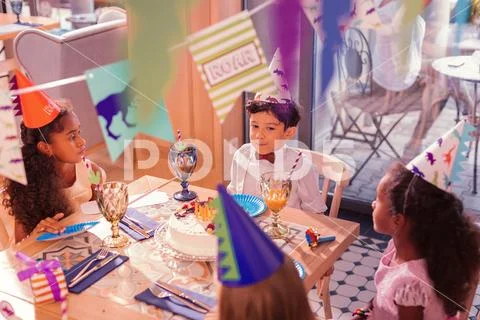Calm kids sitting at the table and waiting for eating the cake Stock Photos