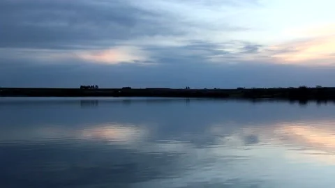 Calm Lake At Cloudy Sunset With Fish Jumping In Water Stock Footage 133964007